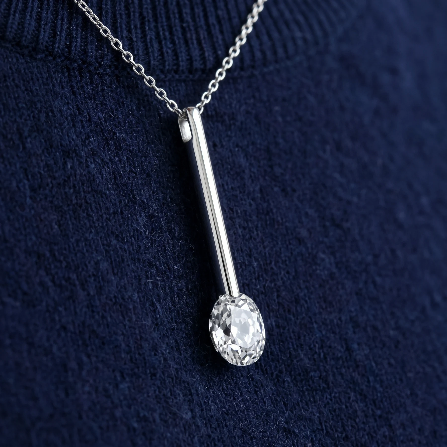 Minimal white-metal pendant concept with an old-cut oval diamond drop