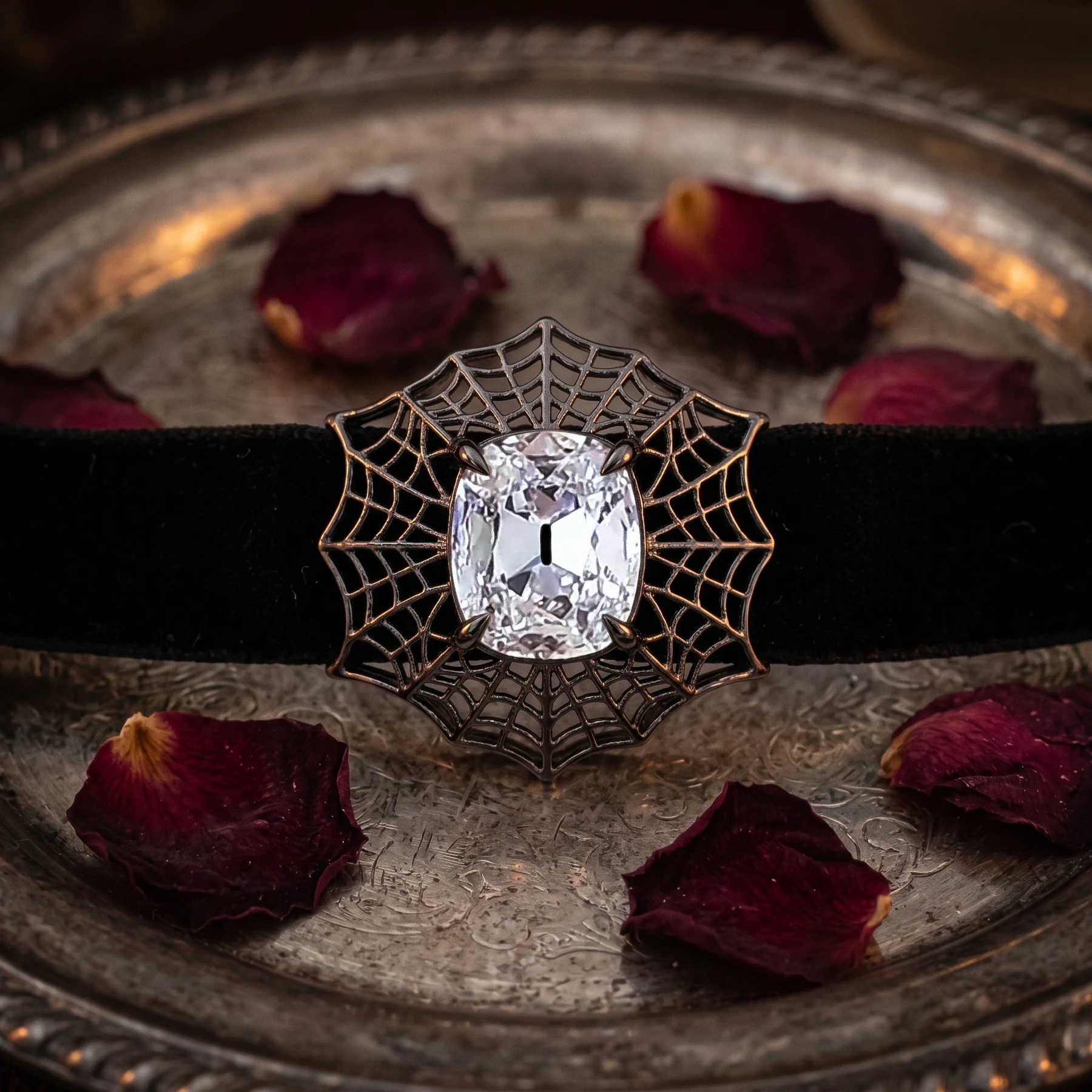 Dark openwork brooch concept centred on a cushion-shaped diamond