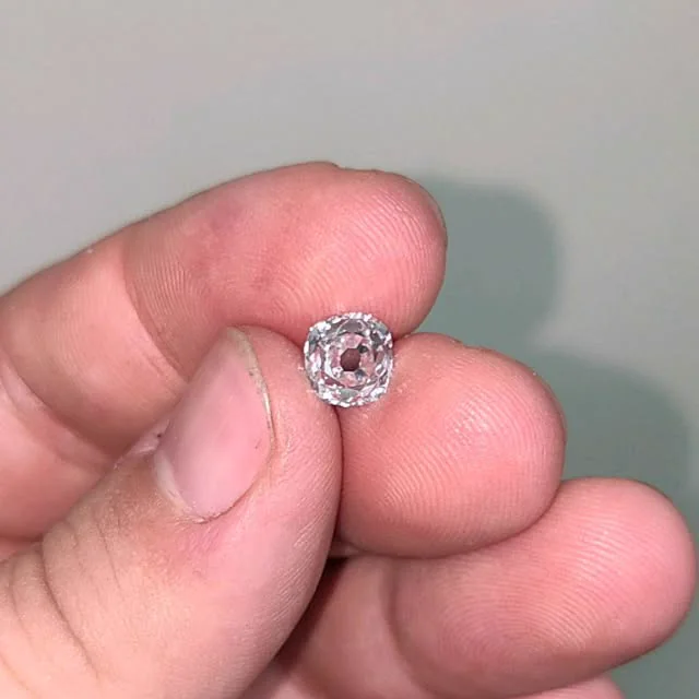 An old-cut diamond in hand