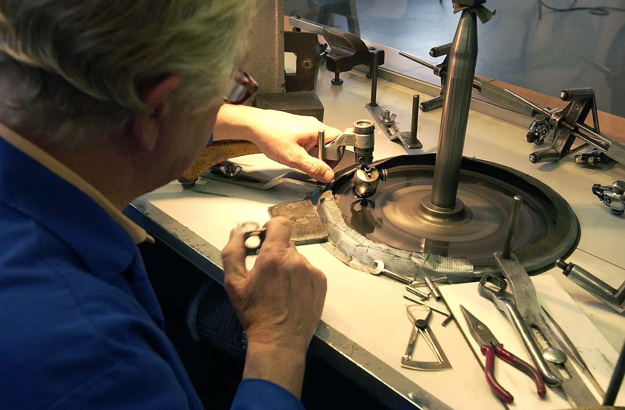 A diamond polisher working at a polishing wheel.