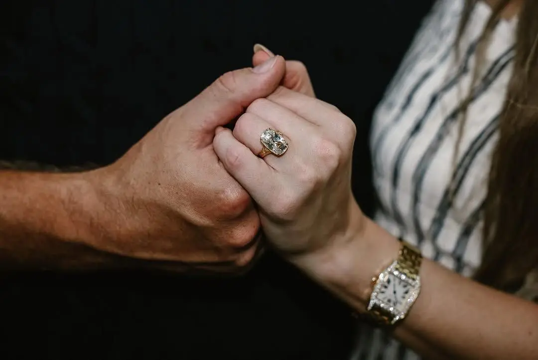 Taylor Swift wearing her engagement ring while holding Travis Kelce's hand.