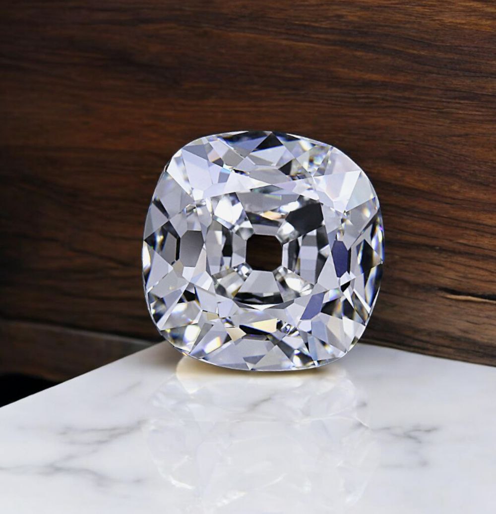 Face-up view of an 8.01 carat H VVS2 old mine cushion showing its open culet and broad antique facets