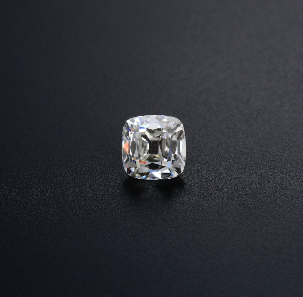 4.02 Ct. K SI1 Old Mine Cushion on textured charcoal, with broad pale reflections around its open culet